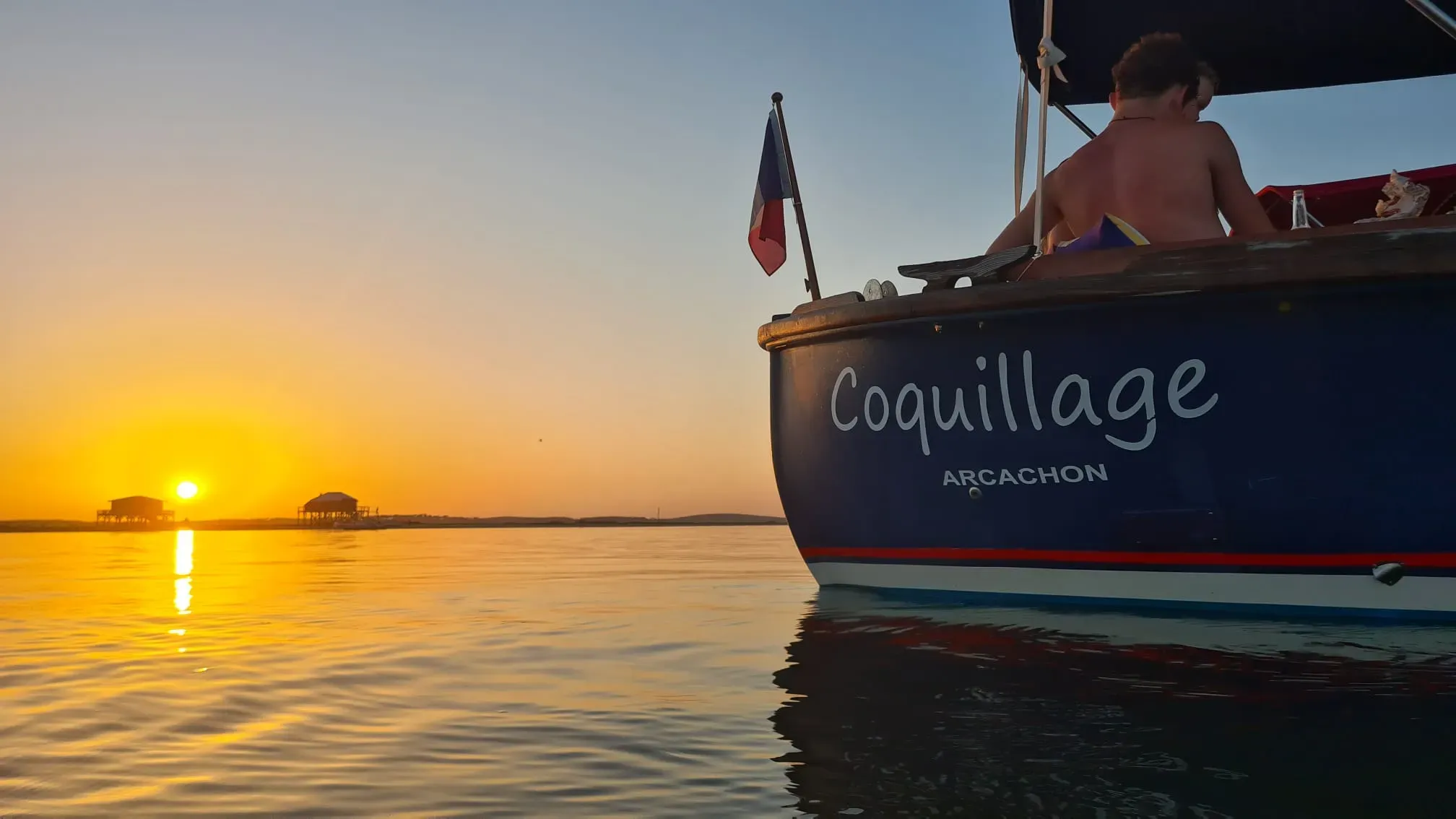 La pinasse Coquillage au coucher du soleil sur le Bassin d'Arcachon, face aux cabanes tchanquées